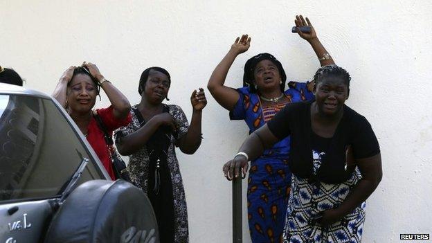 Bystanders react as victims of a bomb blast arrive at the Asokoro General Hospital in Abuja April 14