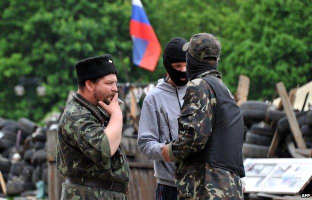 Pro-Russian militants stand by as they maintain a barricade outside the regional state building in the eastern Ukrainian city of Donetsk on May 12, 2014. A presidential election in Ukraine scheduled for May 25 that the West sees as vital to restoring order "will not happen" in the Donetsk region, the self-styled governor of the province Denis Pushilin said Monday.