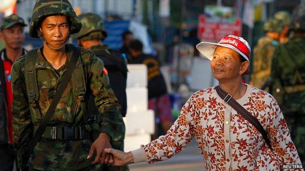 Soldier holds hands with anti-government protester on the outskirts of Bangkok (22 May)