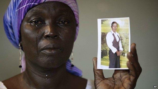 Martha Mark, the mother of kidnapped school girl Monica Mark cries as she display her photo, in the family house, in Chibok, Nigeria, on 19 May 2014