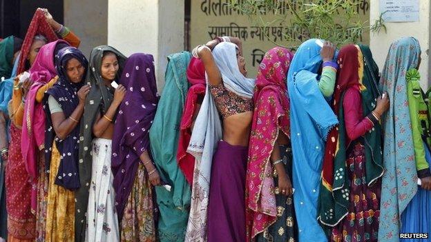 Women wait in a queue to cast their vote at polling station at Sirohi district in the desert Indian state of Rajasthan, April 17, 2014