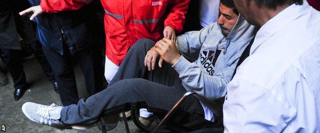 Luis Suarez in a wheelchair after knee surgery