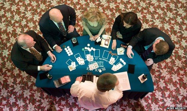 People standing round a blackjack table