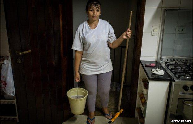 A maid in Brazil with a mop