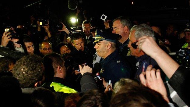 Boston Police Commissioner Edward Davis is surrounded by reporters during a press conference following the Boston Marathon bombings.