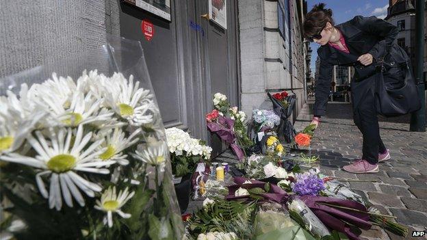 Woman lays flowers at the Jewish Museum in Brussels (25 May)