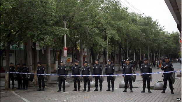 Policemen stand guard near the road leading to the site of Thursday's explosion in Urumqi, China's northwestern region of Xinjiang, Friday, 23 May.