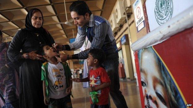 In this photograph taken on May 19, 2014, a Pakistani health worker administers polio vaccination drops to a child at the Karachi International Airport in Karachi.