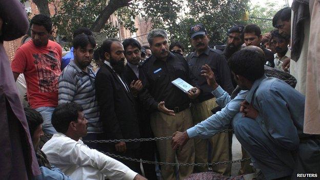 Police collect evidence near the body of Farzana Iqbal, who was killed by family members, at the site near the Lahore High Court building in Lahore May 27