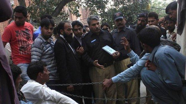 Police collect evidence near the body of Farzana Iqbal, who was killed by family members, at the site near the Lahore High Court building in Lahore May 27