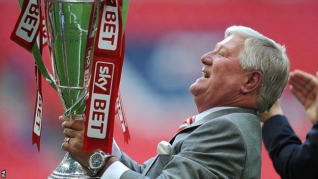 Rotherham United chairman Tony Stewart celebrates with the trophy on the pitch after the final whistle