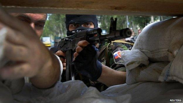 A pro-Russian rebel mans a newly erected barricade on the airport road in Donetsk, 27 May