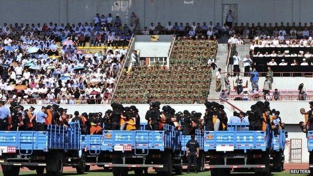 Trucks carrying criminals and suspects are seen during a mass sentencing rally at a stadium in Yili, Xinjiang Uighur Autonomous Region, 27 May 2014