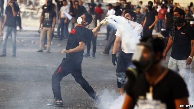 Anti-government protester throws a tear-gas canister at police at a protest in Sitra (27 May 2014)