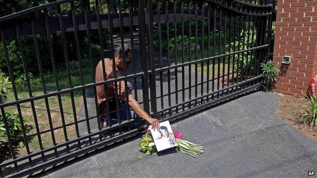 Groundskeeper and security guard for Maya Angelou, James Samuels, retrieves flowers left outside her home in Winston-Salem, North Carolina (28 May)