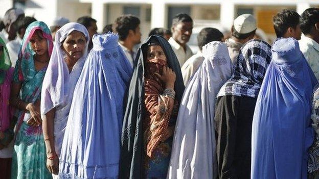 Muslim women, who were displaced by deadly religious strife last year, stand in a queue to cast their votes for the general election at a polling station in Palra village in Muzaffarnagar.