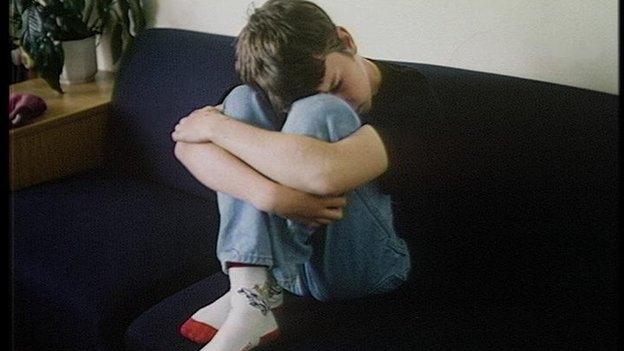 A boy crying with head in hands