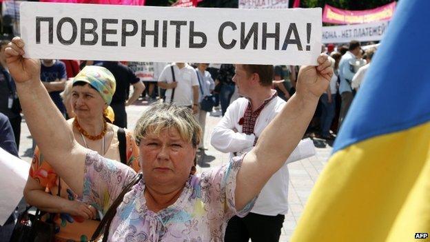 A Ukrainian woman holds up a banner reading "bring back my son" at a rally with other relatives of Ukrainian officers and soldiers in Kiev (29 May 2014)