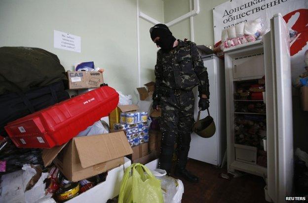 A Vostok fighter shows looted goods he says were looted in Donetsk, 29 May