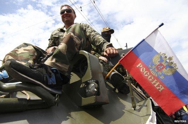 Vostok fighters aboard a troop carrier with a Russian flag in Donetsk, 25 May