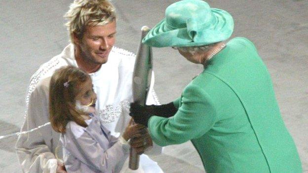 David Beckham and Kirsty Howard hand the Queen's Baton to the Queen.