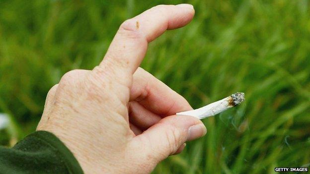 Hand holding cannabis cigarette