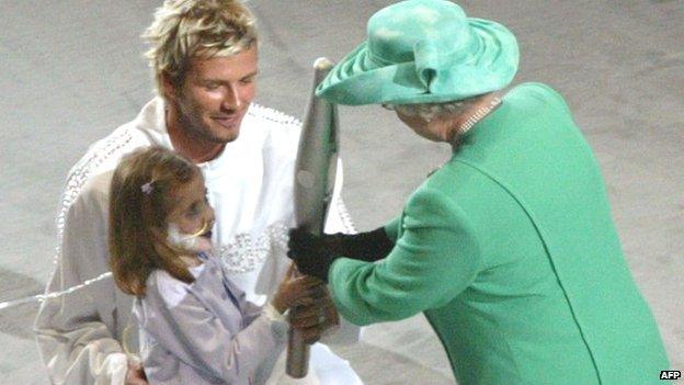 David Beckham and Kirsty Howard hand the Queen's Baton to the Queen.