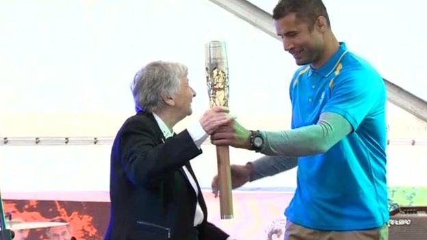 Richard Parks hands the baton to Anne Ellis, president of the Commonwealth Games Council for Wales