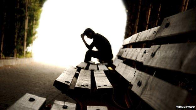 A man on a bench with his head in hands