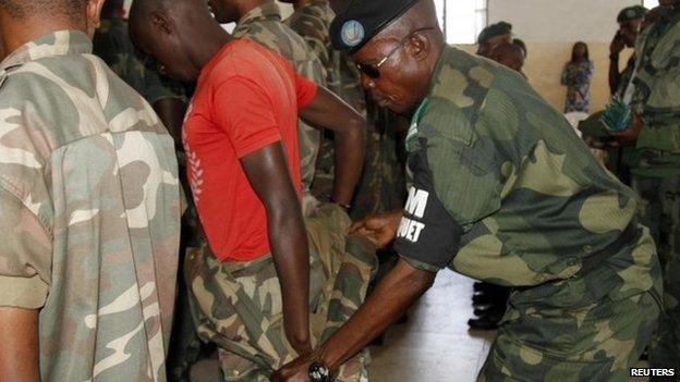 A Congolese soldier is stripped of his rank and uniform after the mass trial of 39 soldiers inside a military court in Goma in eastern Democratic Republic of Congo, on 5 May 2014