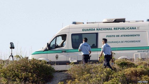 Two Portuguese police walking next to a parked police van