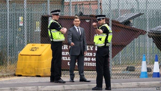 Simon Brodkin being questioned by police at Luton Airport