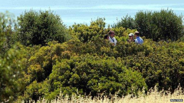 Police searching an area of scrubland in Praia da Luz