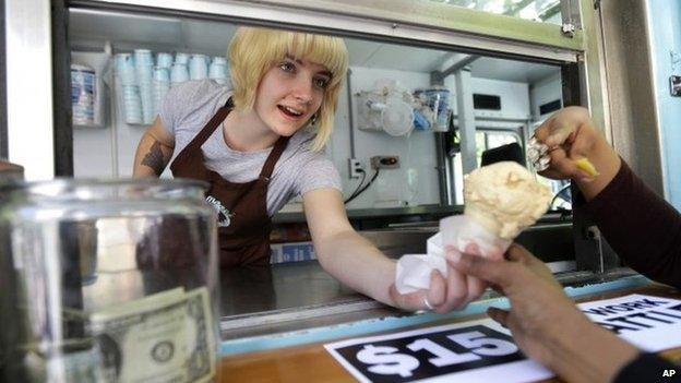 Caitlyn Faircloth, a worker with Molly Moon's Homemade Ice Cream, hands out free ice cream next to a tip jar, 2 June 2014