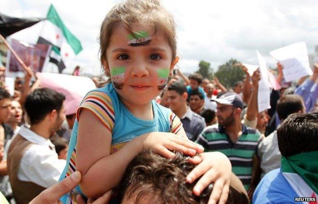 A girl with Syrian opposition flags on her face at a protest against Bashar al-Assad in Tripoli (1 June 2014)