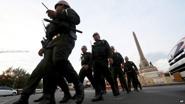 Thai military police officers march while guarding to prevent anti-coup demonstration at Victory Monument Monday, June 2, 2014 in Bangkok,