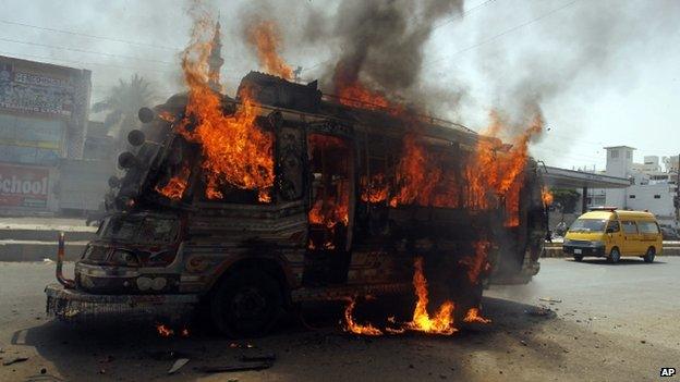 A bus burns in Karachi after it was set on fire by protesters condemning the arrest in London of Altaf Hussain (3 June 2014)