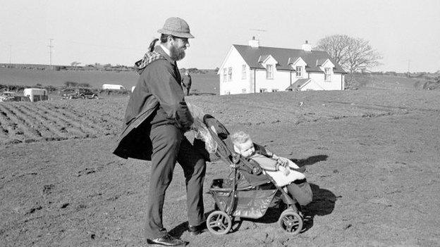 Man pushes buggy across farmland