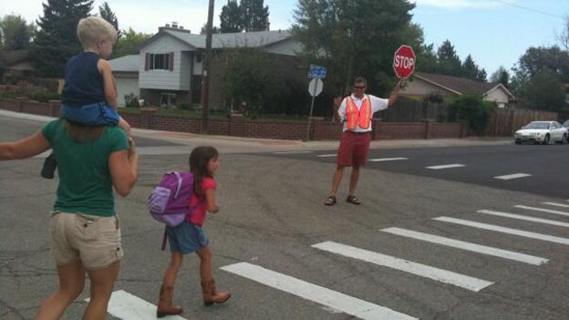 Crossing guard helps children across the street