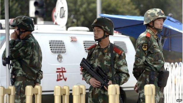 Armed Chinese police stand guard near Tiananmen Square in Beijing on June 4