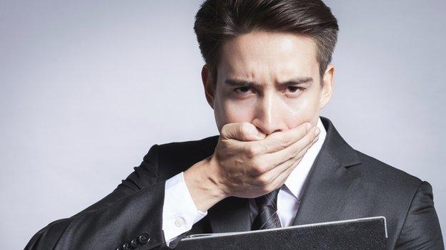 Businessman covering his mouth