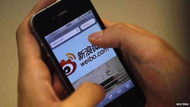 File photo: A man visits Sina's weibo microblogging site using an iPhone in Shanghai