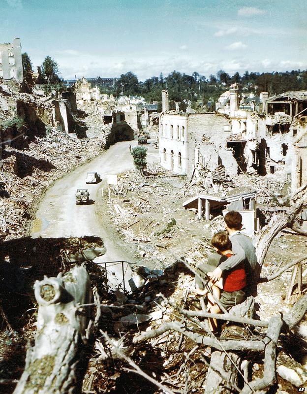 Children standing on rubble in Saint Lo, France, August 1944