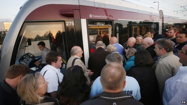 People queue to board a tram