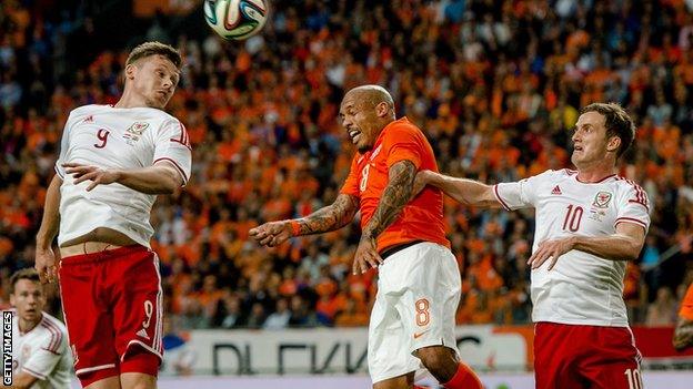 Nigel de Jong (C) of Netherlands vies with Wales players Simon Church (L) and Andy King