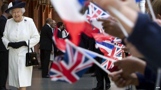 School children waving union jacks as the Queen walks past