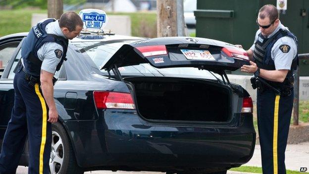 Royal Canadian Mounted Police check the trunk of a taxi at a roadblock in Moncton, New Brunswick, on 5 June 2014