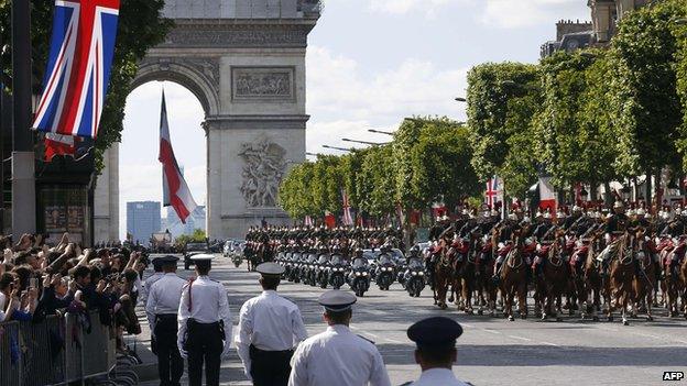 Motorcycle policemen escort the car carrying the Queen and French President Francois Hollande