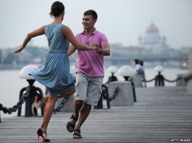 Muscovites dance on the embankment of the Moskva river in central Moscow late evening