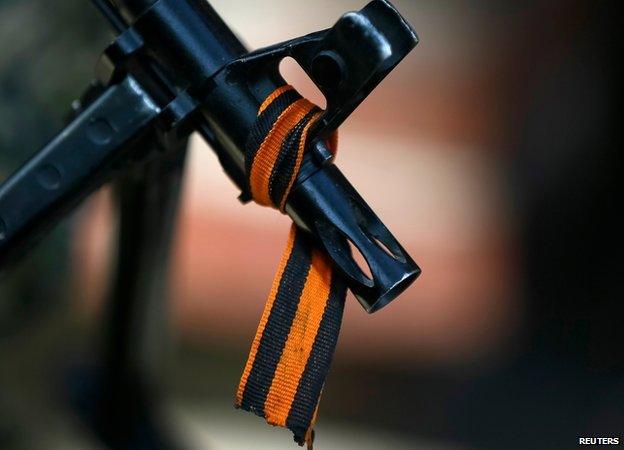 Black and orange ribbon tied around the barrel of a gun